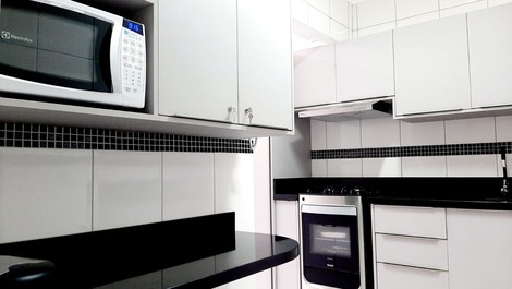 Cozinha totalmente planejada com bancada de apoio para refeições rápidas 