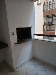 Sacada com churrasqueira com vista para piscina