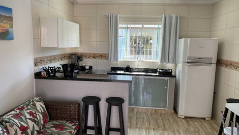 Ambiente integrado sala e cozinha. 3 banquetas pretas são do barzinho da jacuzzi/spa. 