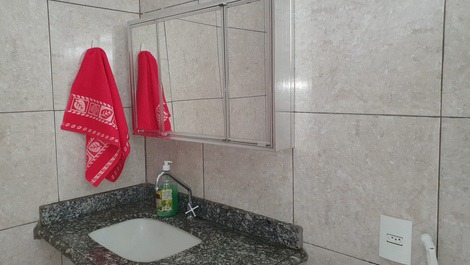 Banheiro com toalha de rosto e armarinho