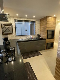 Cozinha moderna com área gourmet integrada a bancada 