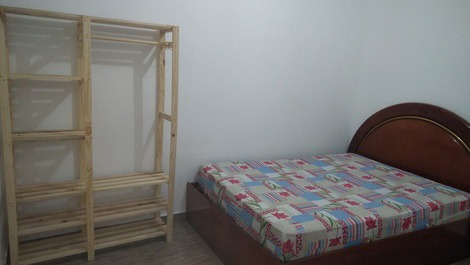 Quarto 02: cama de casal, arara de roupas, ventilador de teto, mesa e ferro de passar. 