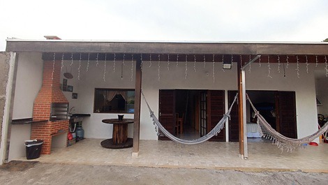 Varanda com churrasqueira e redes com vista para as montanhas.