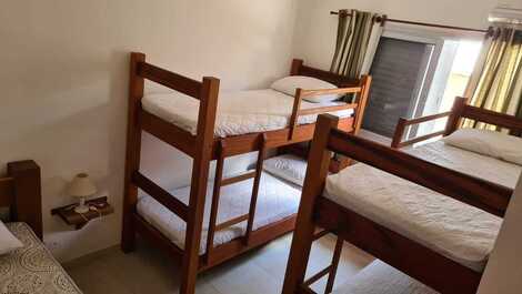 Quarto com dois beliches e uma cama de solteiro. ar condicionado e ventilador