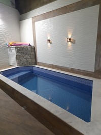 Excelente piscina com deck, banqueta interna com hidromassagem, cascata e iluminação em led.