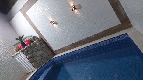 Excelente piscina com deck, banqueta interna com hidromassagem, cascata e iluminação em led.