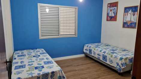 Quarto social com duas bicamas e ventilador de teto 