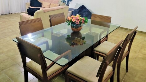 Sala de jantar ampla com mesa de vidro e 6 cadeiras.