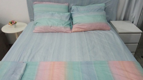 Cama queen bem confortável com 6 travesseiros de diferentes tipos e um colchonete de casal