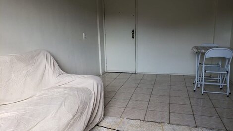 Sala com sofa, mesa de jantar, tv, ventilador.