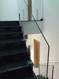 Vista da escada em granito são gabriel e guarda corpo em vidro temperado.