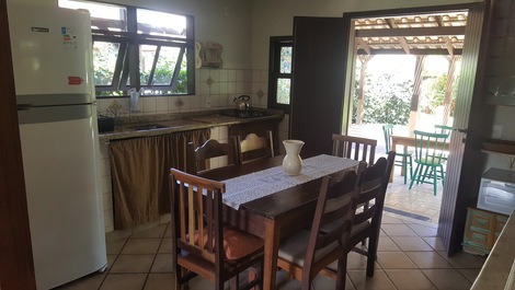 Cozinha com mesa e cadeiras em madeira maciça.