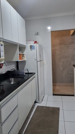 Cozinha americana equipada com fogão, forno, geladeira micro ondas e demais utensílios domésticos