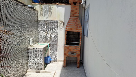 Churrasqueira, lavanderia e ducha com uso compartilhável.