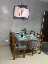 Mesa com 4 cadeiras para as refeições. equipado com pratos, talheres. 