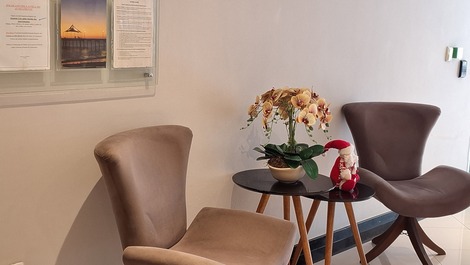 Cadeiras e mesinhas no hall de entrada da portaria.