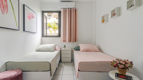 Quarto com duas camas de solteiro ortopédicas e decoração aconchegante.