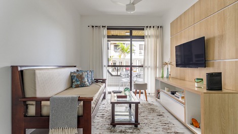 Sala completa com sofá-cama, televisão a cabo, ventilador de teto e decoração praiana.