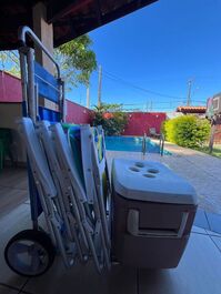 Carrinho de praia, cadeiras de praia e cooler.