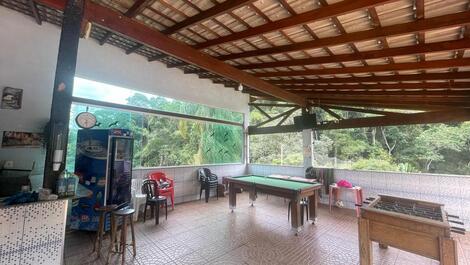 Área externa da churrasqueira com mesa de bilhar, pebolim e freezer.