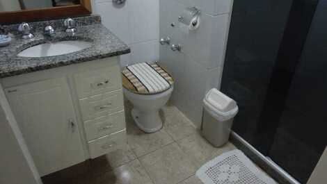 Banheiro social com blindex e ducha quente articulada.