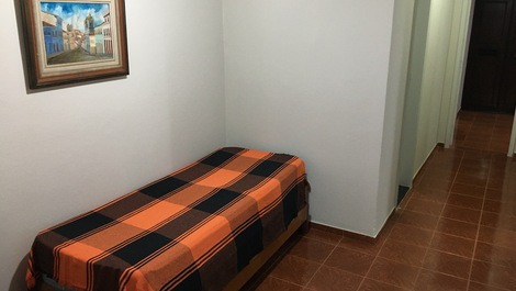 Antessala com cama de solteiro e cama auxiliar