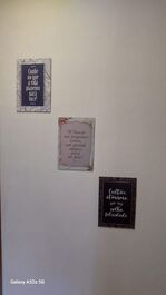 "trio de quadrinhos decorativos com frases na parede do corredor."