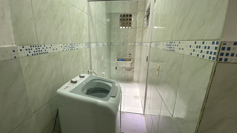 Lavanderia com uma máquina de lavar e um tanque