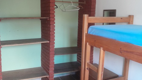 Armário aberto do quarto com 2 beliches.