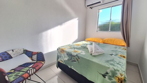 Quarto com cama de casal, ar condicionado, cadeira, armário aéreo e blackout