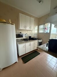 Cozinha com fogão, microondas, geladeira, airfryer, sanduicheira, liquidificador e armários com todos utensílios.