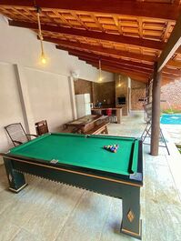 Área gourmet equipada com churrasqueira e utensílios 