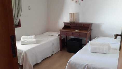 Quarto suíte com duas camas de solteiro e escrivaninha 