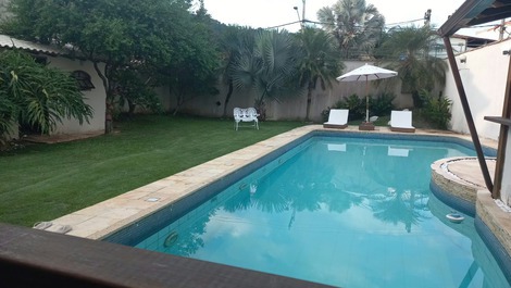 Piscina e área gourmet,com espriguiçadeiras,ombrelone e mesas de jardim