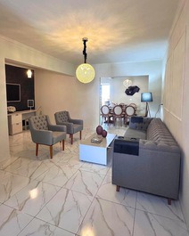 Sala de visita com estofado, poltrona, centro, espelho, mesinha de apoio de alto padrão 