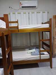 Cama de casal  e uma beliche banheiro dentro do quarto