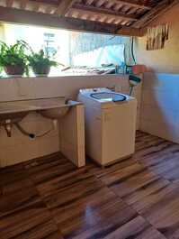 Lavanderia com maquina de 15 kilos e um tanque varal detro e varal fóra no sol