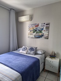 Quarto social com ar condicionado e 1 cama de solteiro.
