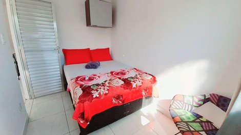 Quarto com cama de casal, ar condicionado, cadeira, armário aéreo e blackout
