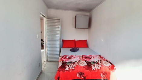 Quarto com cama de casal, ar condicionado, cadeira, armário aéreo e blackout