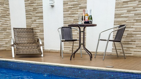 Piscina com cascata, luz de led, e espreguiçadeira, perfeita para relaxar e curtir o sol. 