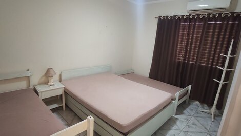 Quarto grande com cama de casal e camas de solteiro