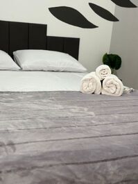 Quarto com roupa de cama e toalhas