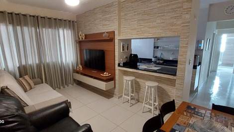 Sala de estar confortável, iluminada, ventilada, com smart tv, sofá expansível, ventilador de teto com controle remoto e wi-fi.