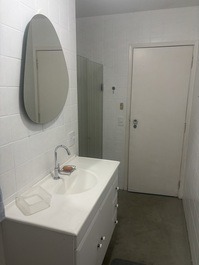 Banheiro social com gabinete e box.