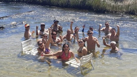 Banho de rio com fundo de areia bem branquinha e águas cristalinas.