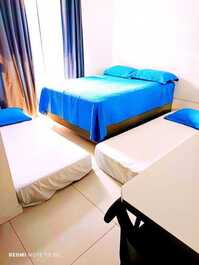 Quarto 1 com uma cama de casal e duas camas de solteiro