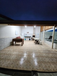 Area de churrasqueira com mesa de pimbolim e geladeira 