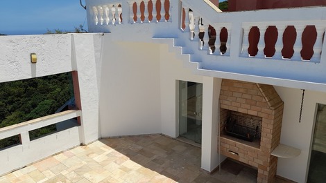 Churrasqueira  da cobertura,  tem cadeiras e mesas