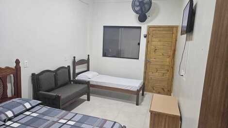 Suíte com cama de casal,  1 cama de solteiro ou um beliche,  um sofá,  1 tv,  banheiro, closet, ventilador de parede arno, cômoda.